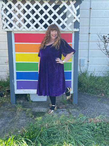 Rebecca wears a purple velvet YOU dress