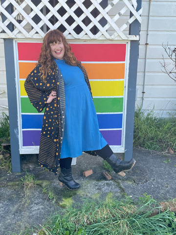 Rebecca wears the space blue KRIS dress with the black & yellow ANJI robe