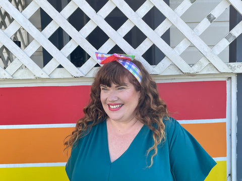 Rebecca wears the Atlantic PENNY ROYALE dress and the gingham Gerty girlband